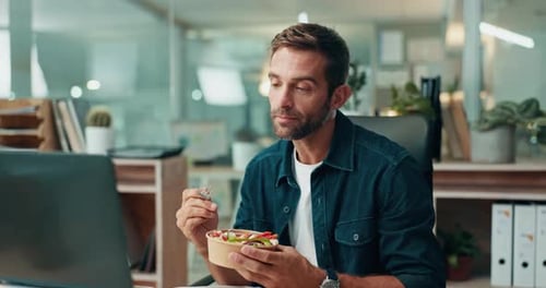Man Eating Salad at Desk in Modern Office