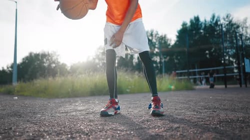 African Teen Boy Playing Basketball View on Legs and Ball on Outdoor Court Skilled Streetballer