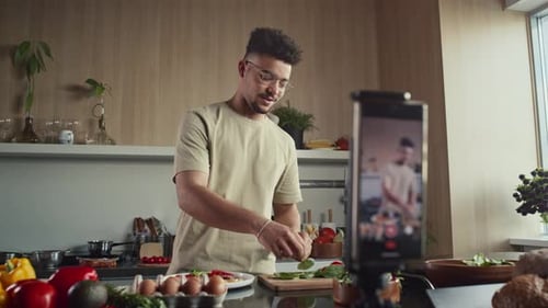 Food-Blogger filmt Koch-Vlog mit Handy auf Stativ