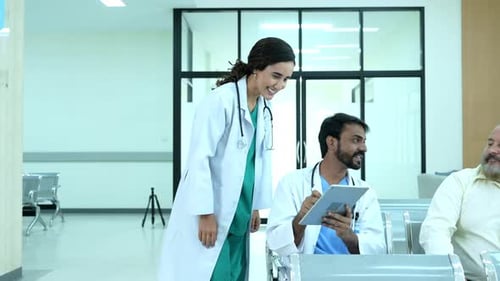 Doctors Reviewing Tablet With Senior Male Patient