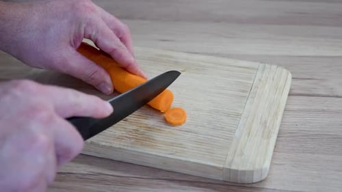 Slicing an Orange Carrot on Cutting Board