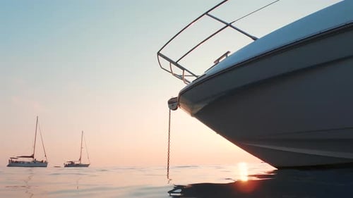 A shot from the water. Luxurious yacht is anchored with some big sailboats at bay.
