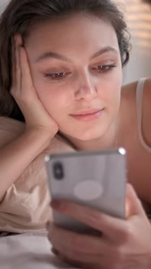 Woman in Bed Using a Mobile Phone