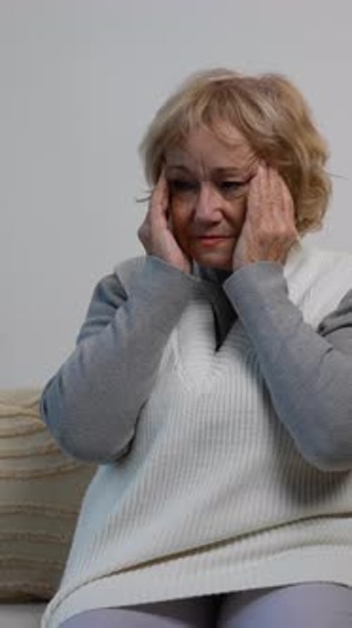 Adult Woman Rubbing Temples in Interior Setting