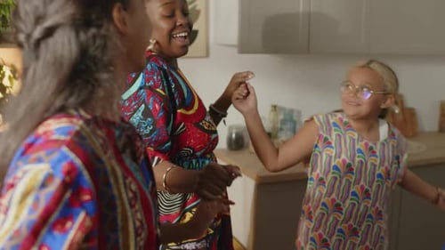Happy Family Dancing Together in Kitchen