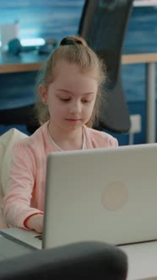 Vertical Video Portrait of Young Girl Working on Laptop for School Lessons