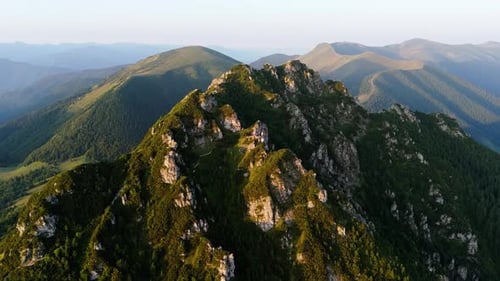Aerial Slow Drone Orbit Shot Around a Majestic Mountain Peak at Sunset