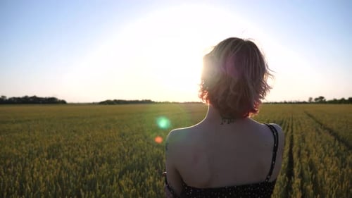 Sensual Young Punk Girl Touching Her Soft Skin with Removed Black Strap of Dress at Wheat Meadow