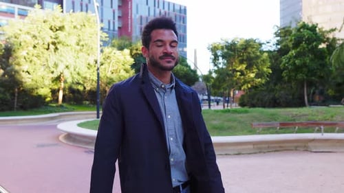 Confident Young Successful Businessman Walking in a City Park