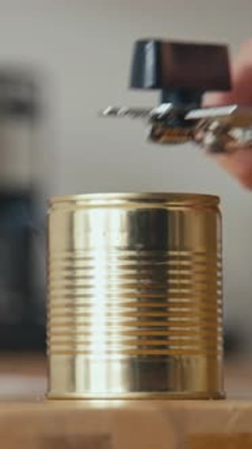 Can Opener Opening Can in a Kitchen