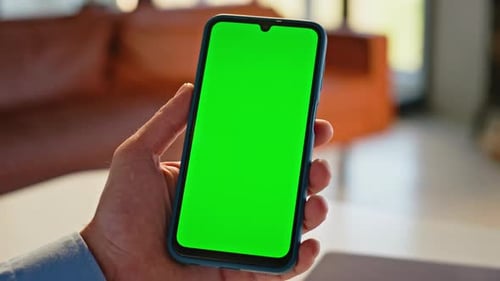 Hand Tapping Smartphone Green Screen Browsing Application in Apartment Closeup