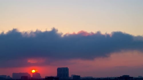 Sunrise and Fast Clouds over City Rooftops