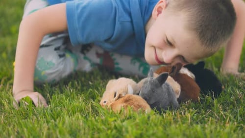 Child Playing with Colorful Baby Rabbits on Lawn