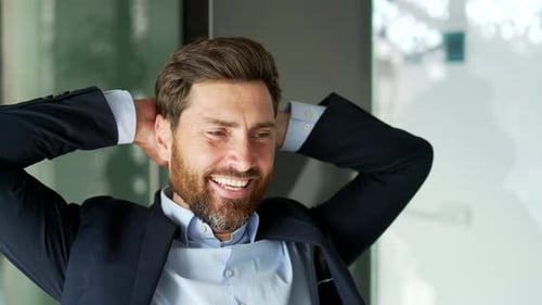 Un homme d'affaires heureux se détend les mains derrière la tête assis sur son lieu de travail dans un bureau d'affaires. Souriant
