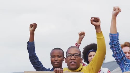 Diverse Group Protesting With Raised Fists Outdoors