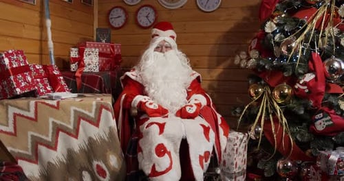 Santa Claus Sitting by a Christmas Tree
