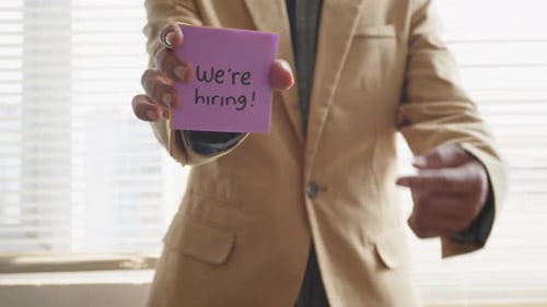 Man In Formal Clothes Holding Job Vacancy Note In The Office