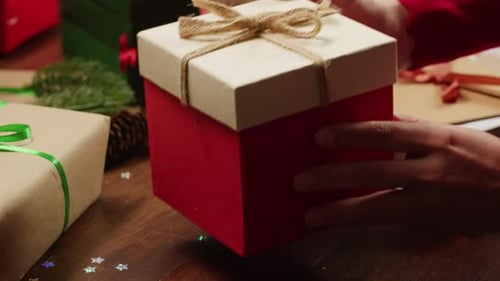 Hands Presenting a Beautifully Wrapped Christmas Gift