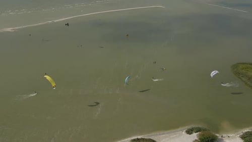 Aerial view of people doing kite surfing along the beach sunny day, Netherlands