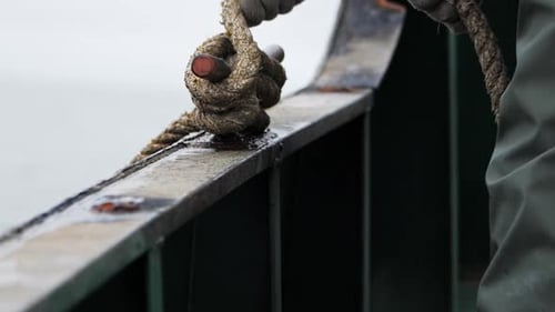 Hands in Closeup Bindeseil in Zeitlupe zeigt die Kunst der Knotensicherung, um Seile auf dem Schiff zu binden