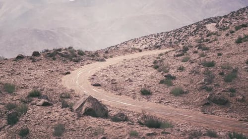 Winding Dirt Road Through the Rugged Terrain of Pamir Mountains in Tajikistan