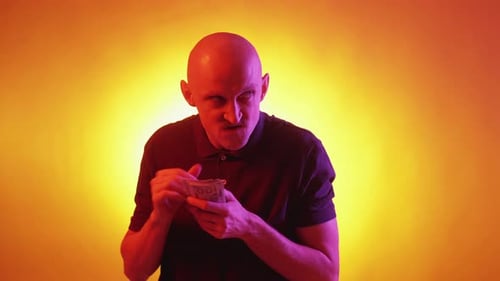 Bald Man Counting Stack of Hundred Dollar Bills