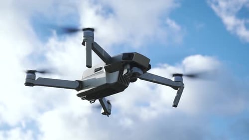 Drone Flying in a Cloudy Blue Sky