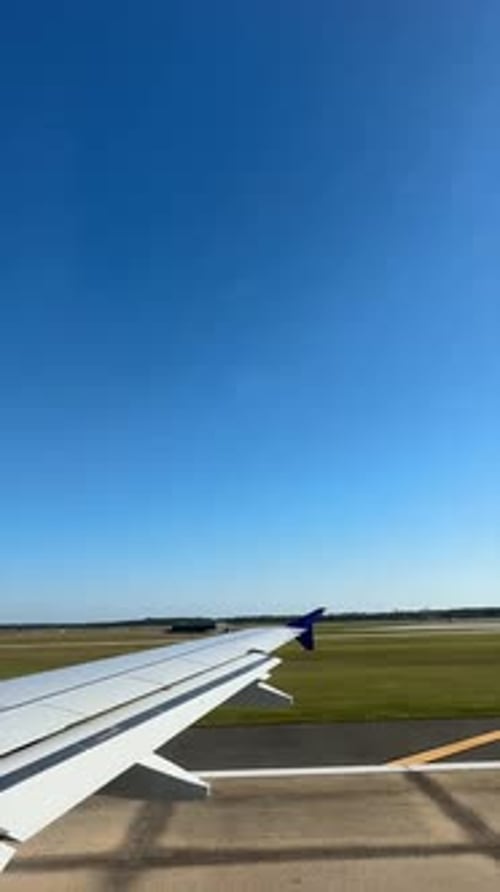 Vue depuis la fenêtre sur l'aile de l'avion pendant le taxi sur la piste avec un ciel clair