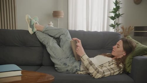 Woman Relaxing and Reading a Book on Couch