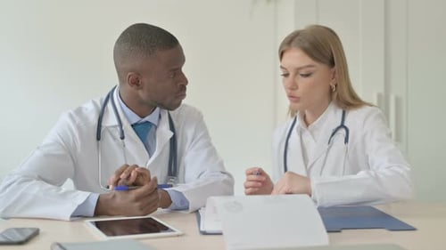 Doctors Reviewing Medical Documents at Office Table