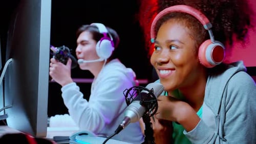Young African American woman and asian man a podcast interview and conversation together in studio.
