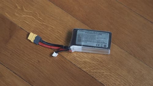 Lonely lithium-polymer battery on the wooden parquet. Soft zoom shot