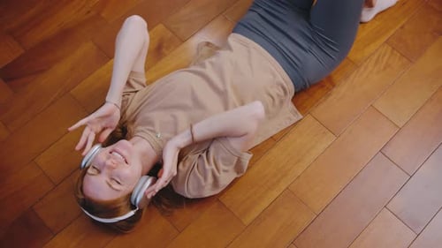 Woman Listening to Music Lying on Floor