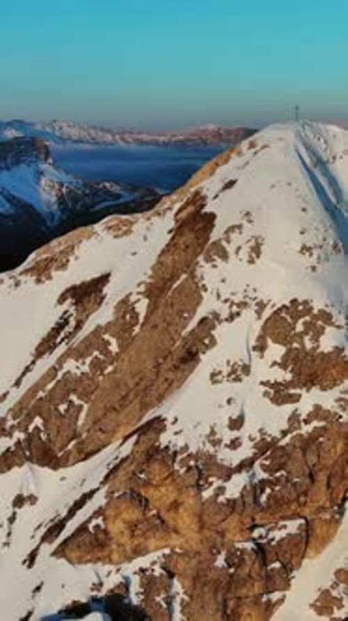 Rocky snow mountains at sunrise aerial