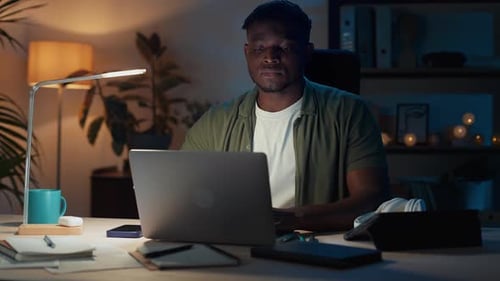 Young Adult Working Late at Home on Laptop