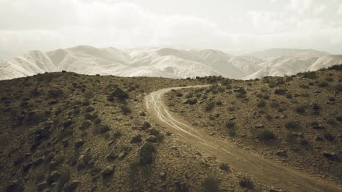 Route de terre sinueuse à travers le terrain accidenté du Pamir au Tadjikistan