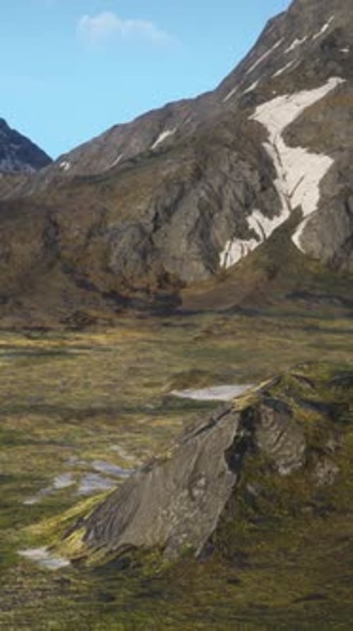 A Mountain Range Covered in Snow and Grass