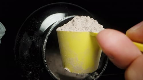 POV Hand Pouring Protein Powder into a Shaker, Slow Motion Close-Up.