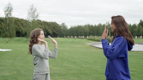Daughter Gives Mom a High Five Outdoors in the Park