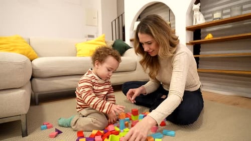 Mother and Toddler Son Building a Colorful Tower with Wooden Blocks