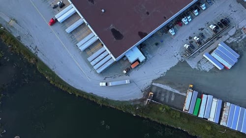 Top View Of Industrial Warehouse Complex With Semi Trucks And Loading Bays