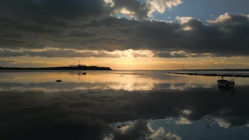 Drone Shot Of A Coastal Sunset Under Cloudy Skies
