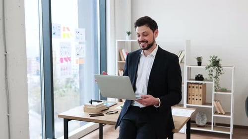 Businessman Discussing Ideas While Using Laptop in Modern Office Setting