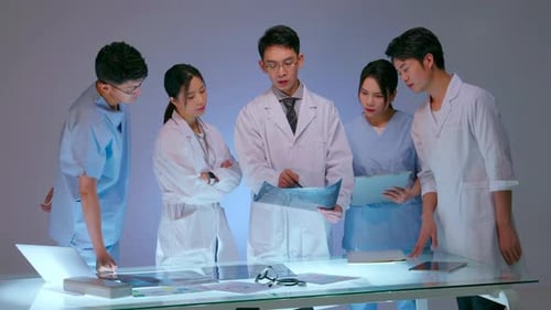 Medical Team Examining X-Ray on Illuminated Table