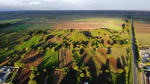 An area lit with light filtering through clouds casting long shadows, drone footage