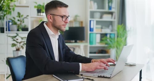 Real Estate Agent Writing on Laptop Preparing Offer