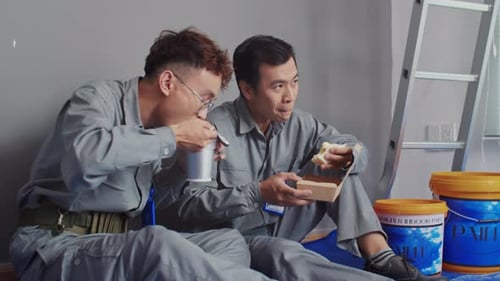 Workers Having Break while Eating at Construction Site