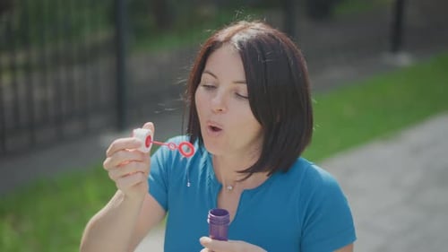 Woman Blowing Bubbles on a Sunny Day Outdoors