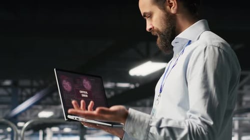 Annoyed Engineer in Data Center Reacting to Critical Error Message on Laptop