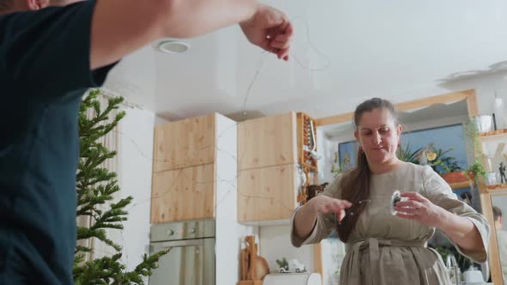 Un mari aide sa femme à installer des lumières de Noël pendant que la ...